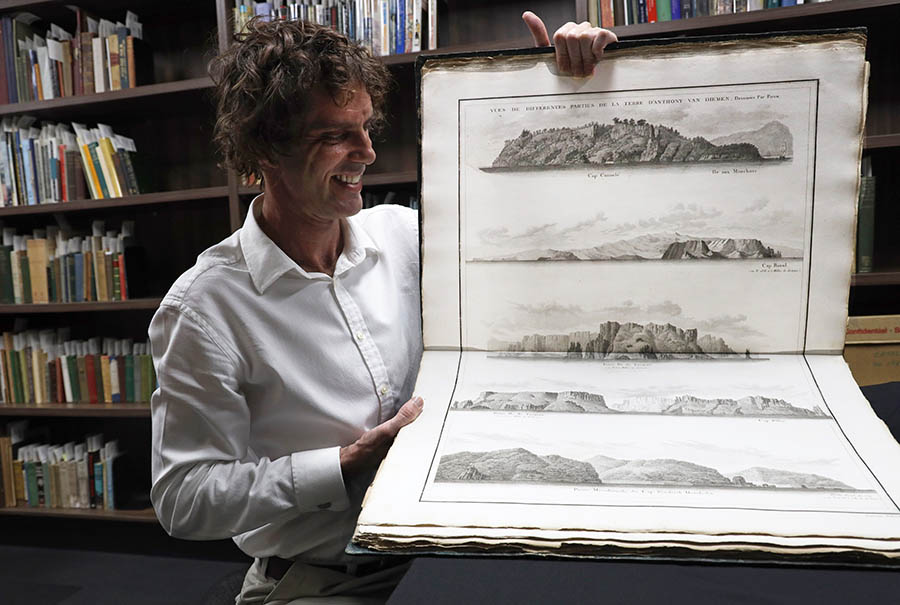 Man holding atlas inside HCCA collection room